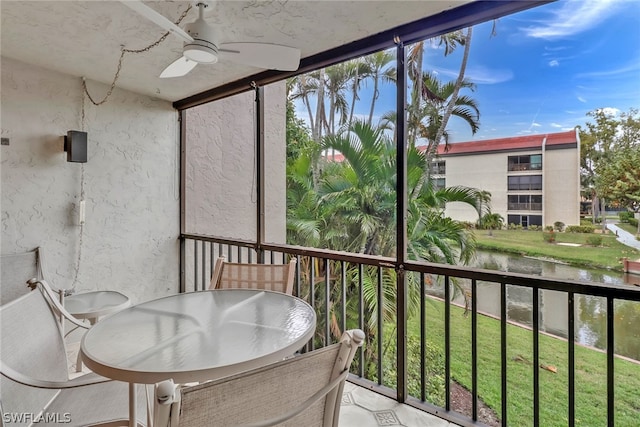 balcony featuring ceiling fan and a water view