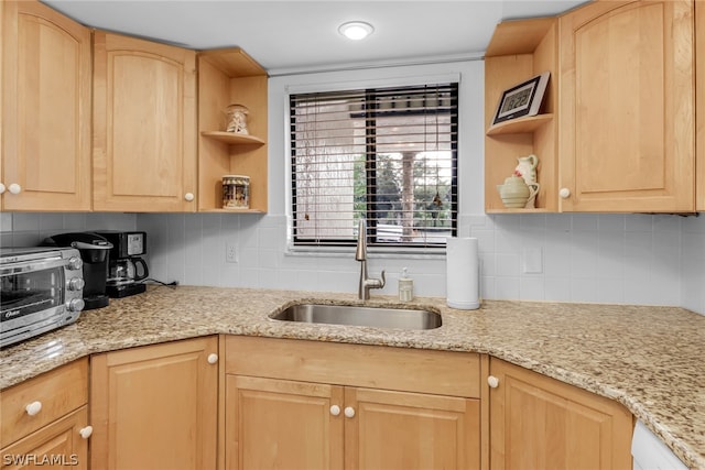 kitchen featuring tasteful backsplash, light brown cabinets, open shelves, and a sink