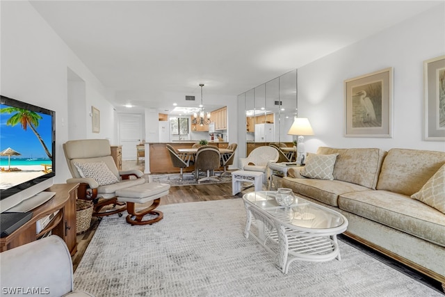 living room with hardwood / wood-style floors and a notable chandelier