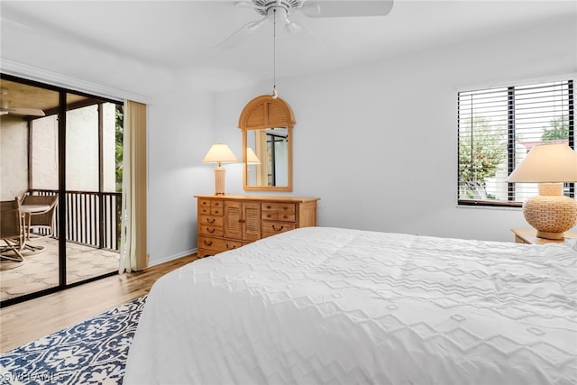 bedroom featuring hardwood / wood-style floors, access to exterior, and multiple windows