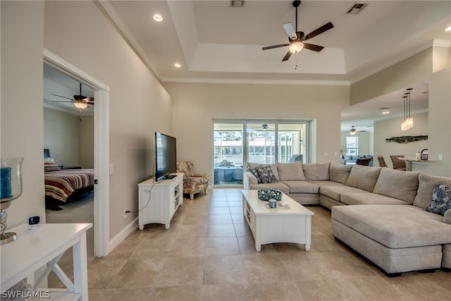 tiled living room featuring a raised ceiling, ceiling fan, and a high ceiling