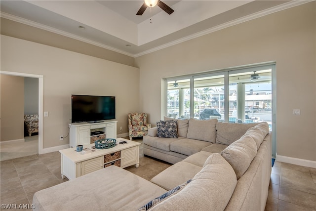 tiled living room featuring ceiling fan and a tray ceiling