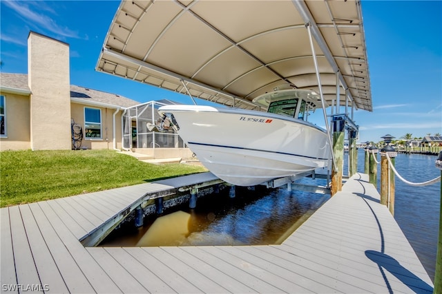 dock area featuring a water view, a lanai, and a yard