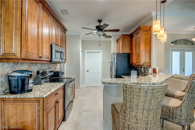 kitchen featuring pendant lighting, stainless steel appliances, french doors, a breakfast bar area, and backsplash