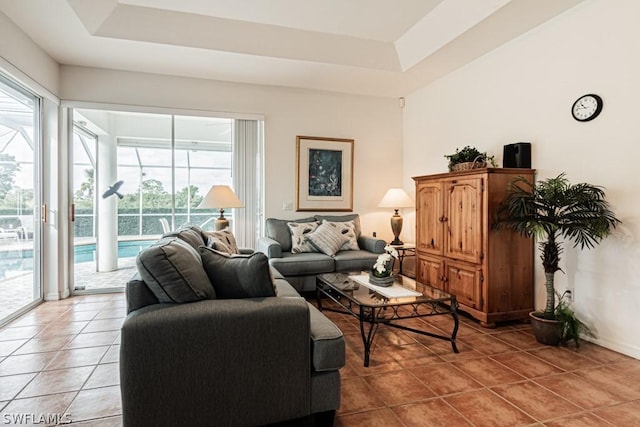 living room with tile patterned flooring and a tray ceiling