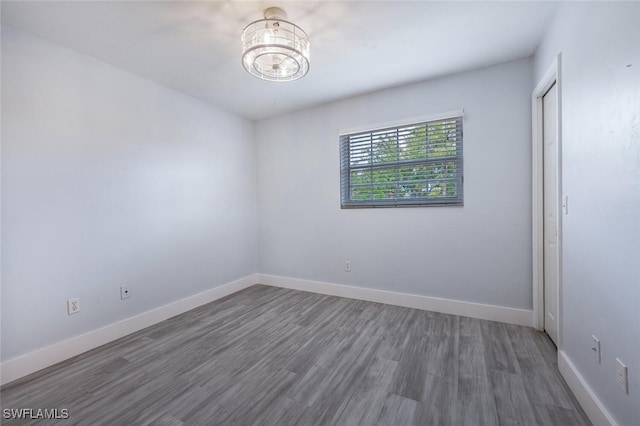 374 Dover Pl Unit 803, Naples, FL 34104 - unfurnished room with baseboards, a notable chandelier, and wood finished floors