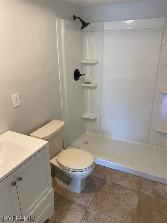 bathroom with toilet, tile floors, and vanity