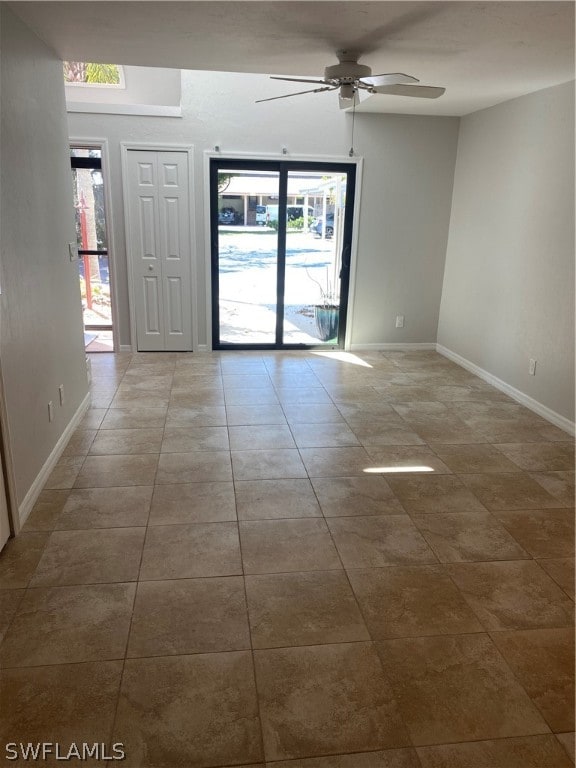 tiled empty room featuring ceiling fan