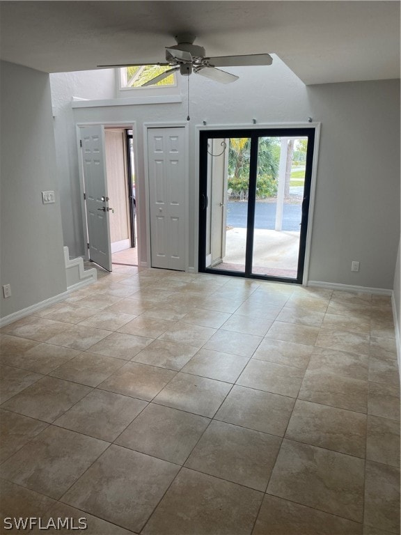 tiled empty room featuring a healthy amount of sunlight and ceiling fan