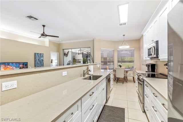 kitchen with white cabinets, pendant lighting, light tile patterned floors, and appliances with stainless steel finishes