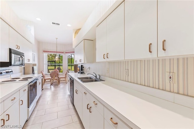 kitchen featuring black appliances, decorative light fixtures, white cabinetry, and sink