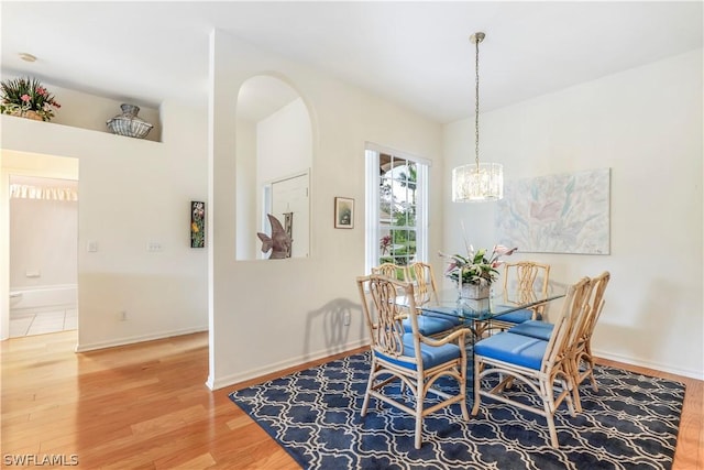 dining area featuring hardwood / wood-style floors and a notable chandelier