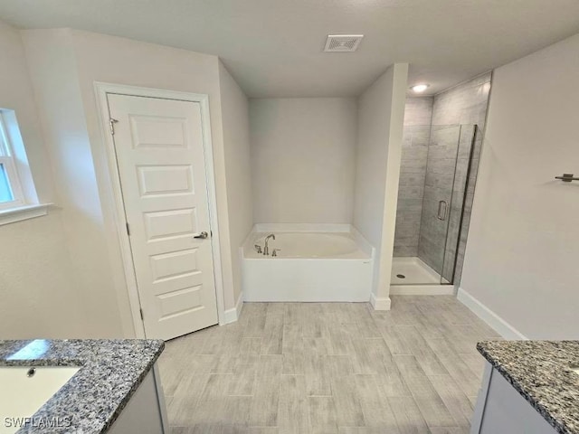 bathroom with separate shower and tub, vanity, and hardwood / wood-style flooring