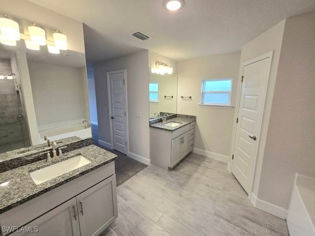 bathroom with hardwood / wood-style floors, vanity, and a bathtub