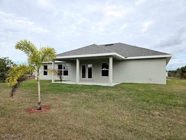 rear view of property featuring a lawn and a patio