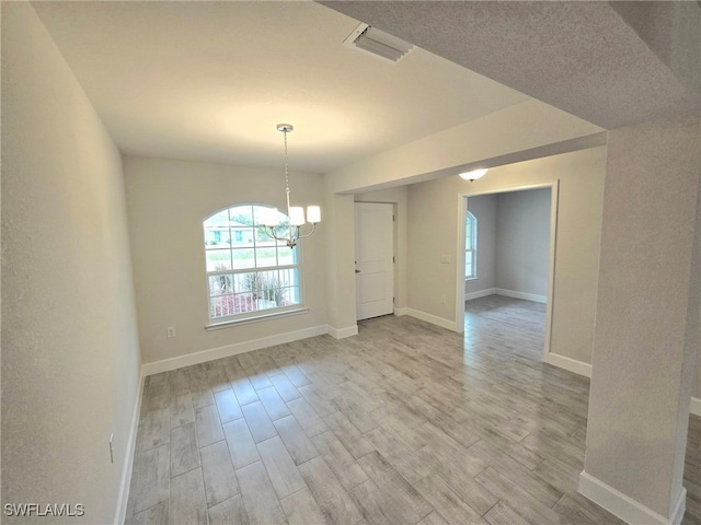 interior space featuring light hardwood / wood-style floors and an inviting chandelier