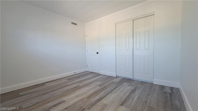 unfurnished bedroom with a closet and light hardwood / wood-style flooring