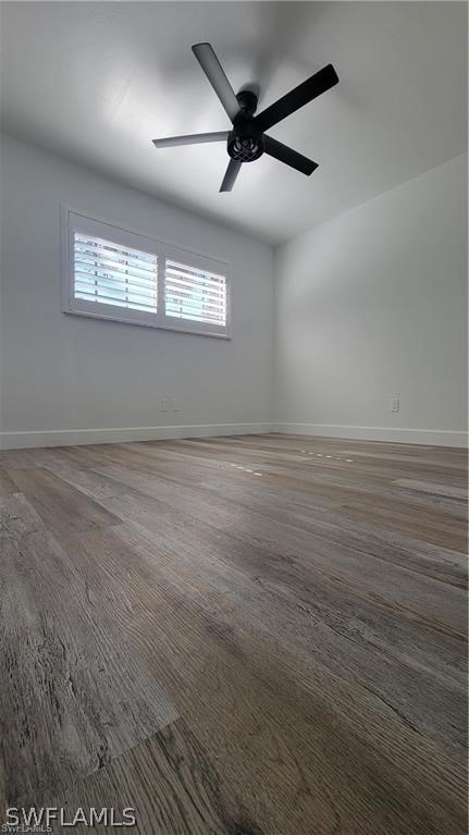 spare room featuring dark wood-type flooring and ceiling fan