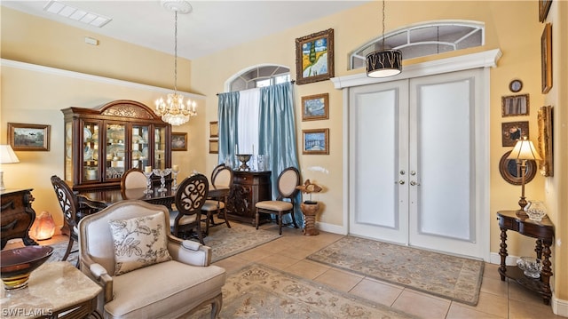 foyer entrance with a notable chandelier, light tile patterned floors, and french doors