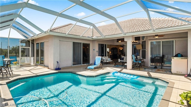 view of pool with ceiling fan, a patio area, and glass enclosure