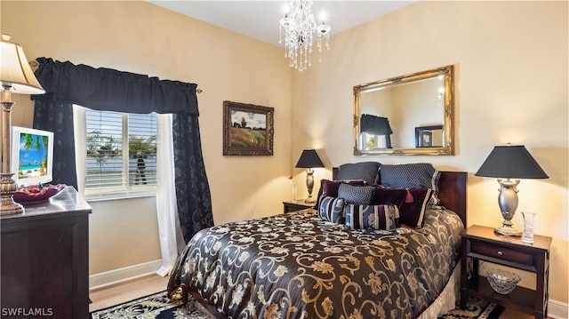 bedroom with hardwood / wood-style floors and a chandelier