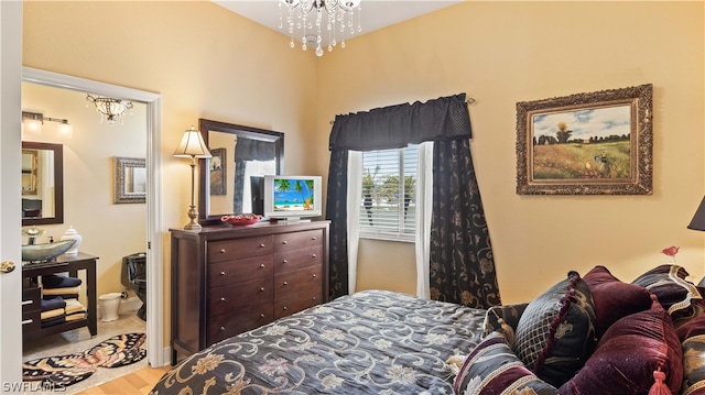 bedroom with light wood-type flooring, an inviting chandelier, and sink