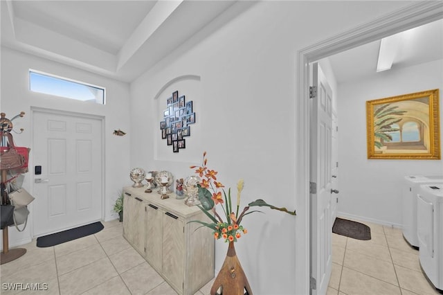 tiled entryway with washer and dryer