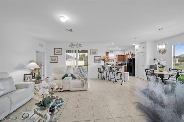 living room featuring light tile patterned floors and an inviting chandelier