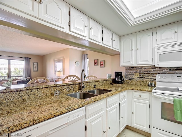 kitchen featuring light stone counters, sink, white cabinets, and white appliances