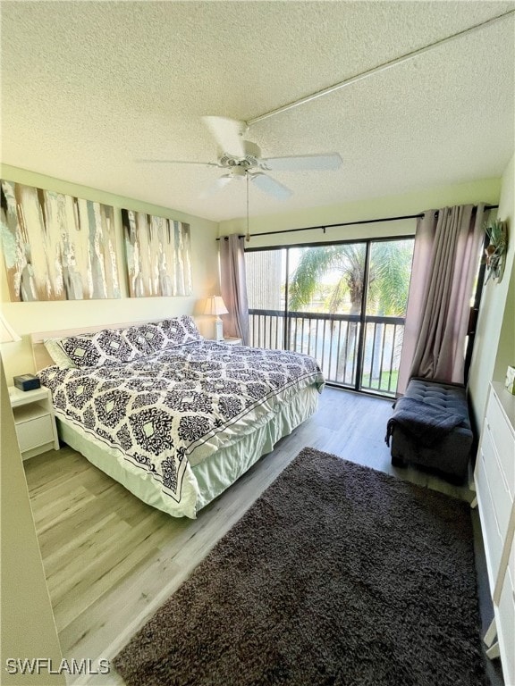 bedroom with access to outside, ceiling fan, a textured ceiling, and hardwood / wood-style flooring