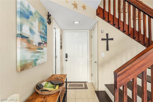 entrance foyer featuring light tile patterned floors and stairs