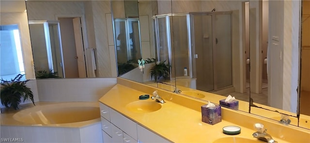 bathroom featuring a garden tub, double vanity, and a sink