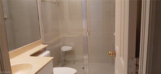 bathroom with toilet, vanity, and a shower with shower door