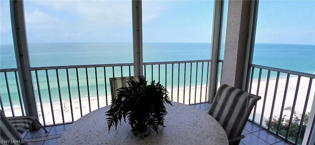 balcony with a water view and a view of the beach