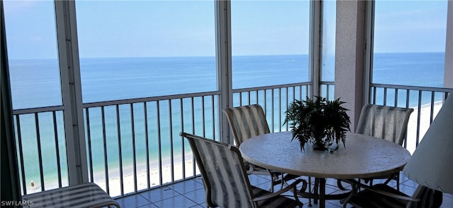 sunroom with a water view and a beach view