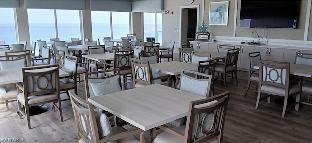 dining space with a water view and wood finished floors