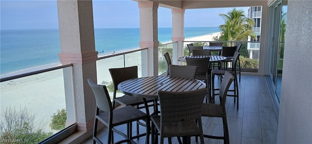 balcony with a water view and a beach view