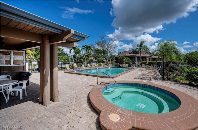 view of pool with a patio and a hot tub