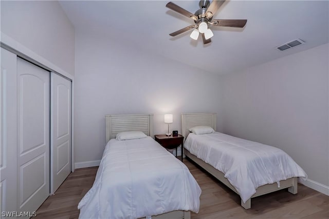 bedroom featuring ceiling fan, a closet, and hardwood / wood-style flooring