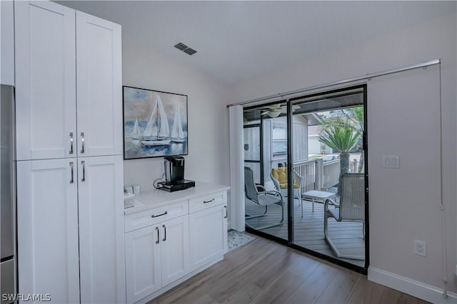 doorway featuring light hardwood / wood-style floors and vaulted ceiling