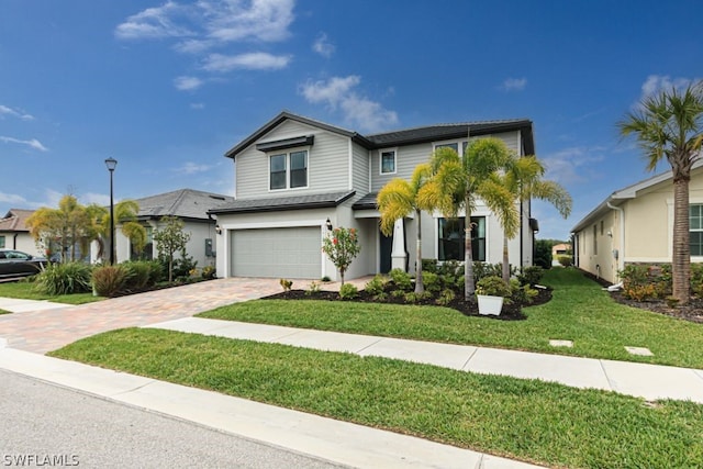 view of front of home with a front yard and a garage