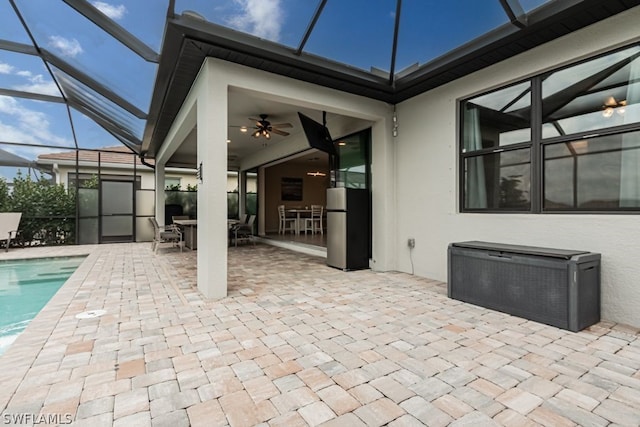 view of patio with ceiling fan and glass enclosure