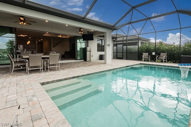 view of pool with a lanai, ceiling fan, and a patio