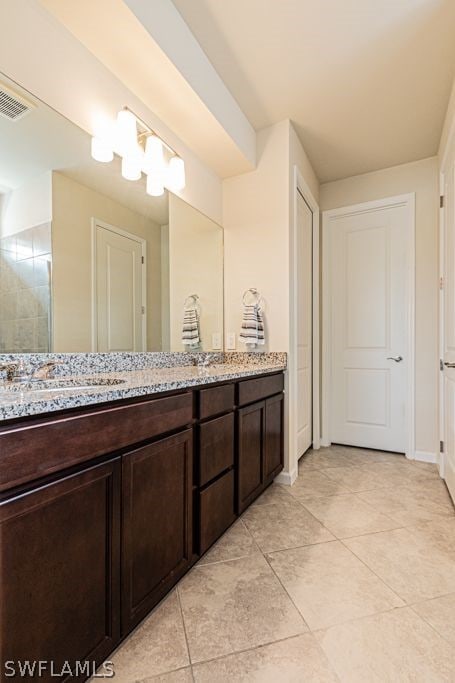 bathroom with tile floors and dual bowl vanity