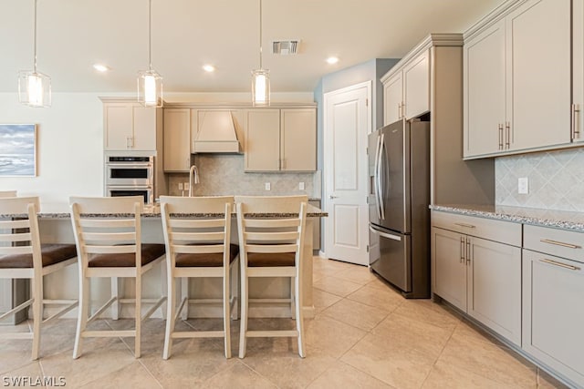 kitchen featuring custom range hood, tasteful backsplash, stainless steel appliances, and pendant lighting