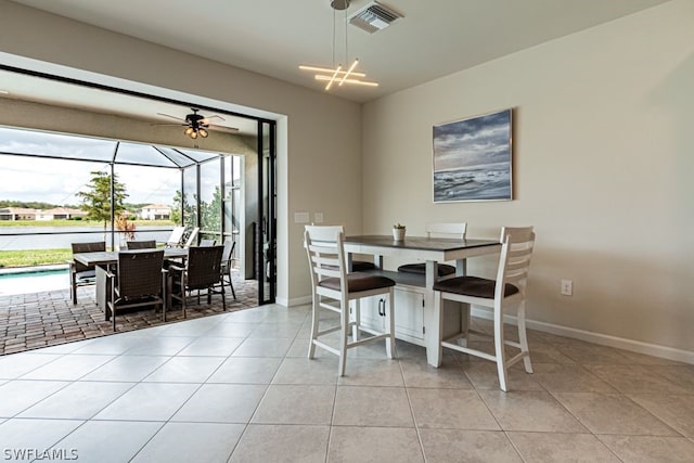 dining space with light tile floors, ceiling fan with notable chandelier, and a wealth of natural light