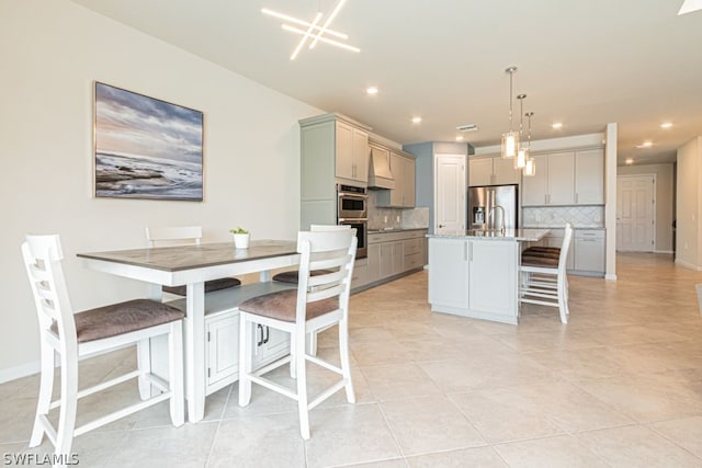 dining area with light tile floors, a chandelier, and sink