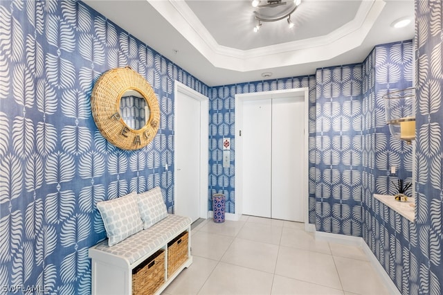 interior space featuring light tile patterned flooring, crown molding, and a tray ceiling