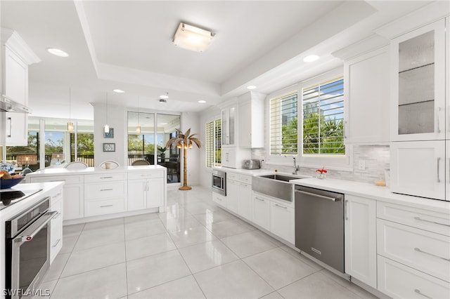 kitchen featuring white cabinets, stainless steel appliances, and backsplash