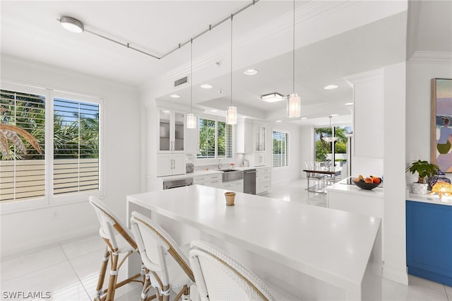 kitchen with white cabinetry, plenty of natural light, pendant lighting, and crown molding